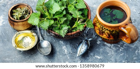 Cup of healthy herbal tea with nettle.Tea with nettles.Fresh stinging nettles