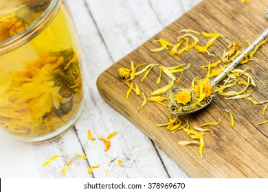 Cup Of Healthy Marigold Tea And Drying Flowers