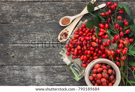 cup of herbal Dog rose tea with bunch branch Rosehips, types Rosa canina hips, essential oil. Medicinal plants and herbs composition 