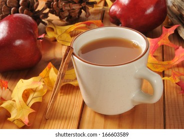 A Cup Of Hot Apple Cider With Cinnamon Sticks