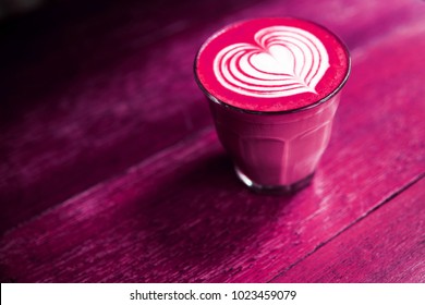 Cup Of Hot Beetroot Latte Coffee Is Standing On The Painted Wooden Background. Trendy Healthy Drink