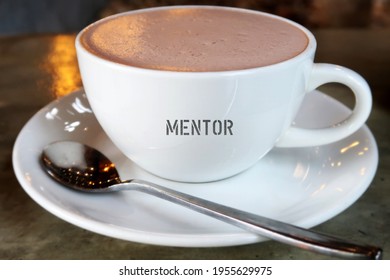 A Cup Of Hot Beverage With Text MENTOR , The One Who Help Develops And Growth To Mentee , Source Of Wisdom Teaching Advice And Support