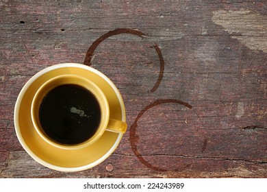 Cup Of Hot Black Coffee On Rough Wooden Table With Stain Rings