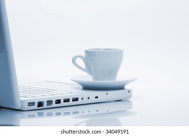 Cup Of Hot Black Steaming Coffee On A Laptop Computer