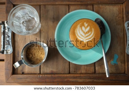 A cup of hot caffee on the plate is placed with a mug of sugar on the table. Breaking time with a cup of coffee.