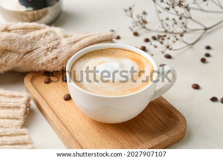 Cup of hot cappuccino coffee on table