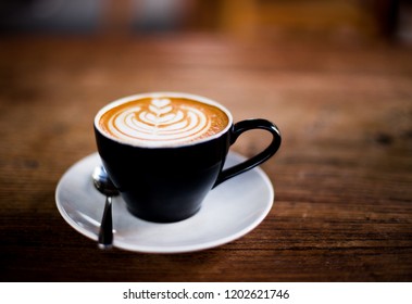 Cup of hot cappucino is on the wooden table. It is an art on the latte. - Shutterstock ID 1202621746