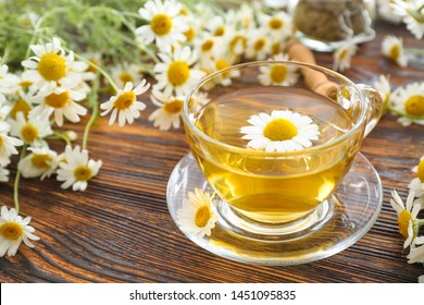 Cup of hot chamomile tea on wooden table