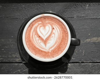 a cup of hot chocolate or coffee on a black saucer. The drink has a latte art design on top in the shape of a heart. - Powered by Shutterstock - Get 15% off with code: PIKWIZARD15