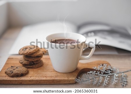 A cup of hot chocolate and cookies on wooden tray for winter background