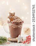 Cup of hot chocolate with whipped cream, gingerbread cookies and candy cane. background with garland lights bokeh. Christmas and New Year sweet dfink and food holiday concept