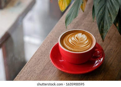 cup of hot coffee latte art on wood table background