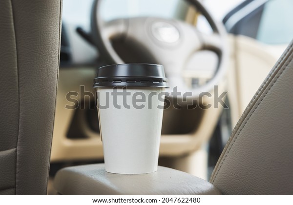 A cup of hot coffee put on the car
console. Drinking coffee while travel by
car.