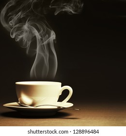 Cup Of Hot Coffee With Steam On Dark Background. Toned Image.