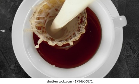 A Cup Of Hot Coffee Or Tea With Pouring Milk, Closeup, Overhead View.