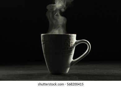 A Cup With A Hot Drink And Steam On Dark Background.