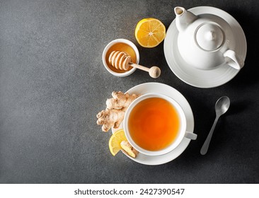 Cup of hot ginger tea with fresh ginger root and lemon on grey background. - Powered by Shutterstock