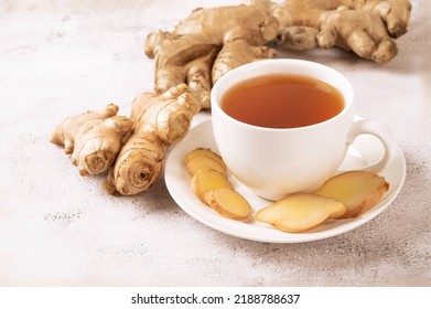 Cup of hot ginger tea with ginger root and slices  on gray background. - Shutterstock ID 2188788637