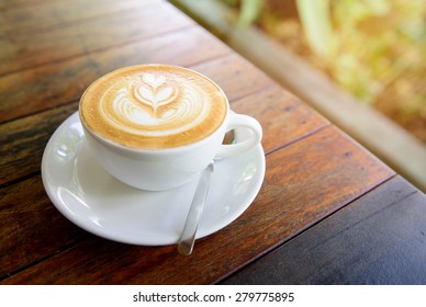 A Cup Of Hot Latte Art Coffee On Wooden Table