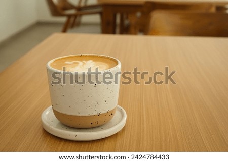 A cup of hot latte coffee on the table for breakfast

