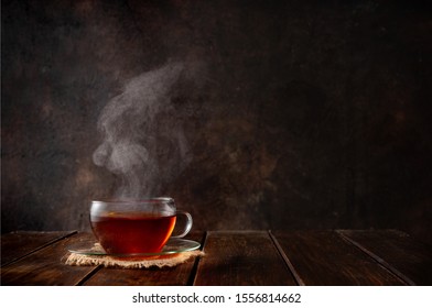 Cup Of Hot Tea With A Steam On Dark Rustic Background. Copy Space