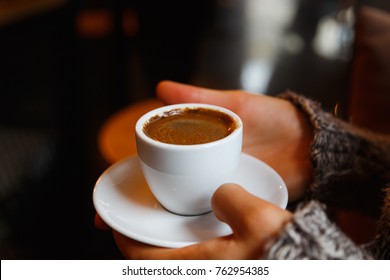 A Cup Of Hot Turkish Coffee In White Cup In Women's Hands. Black Coffee. Warm, Strong  Drink