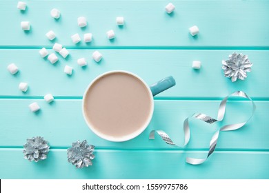 A cup of hot winter beverage, silver winter decorations on the table, top view.  - Powered by Shutterstock