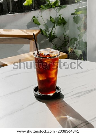 A cup of iced americano coffee on the table.