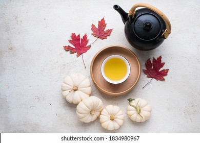 Cup Of Japanese Green Tea On A Wooden Tray With Ceramic Teapot Decorative Pumpkins And Autumn Leaves