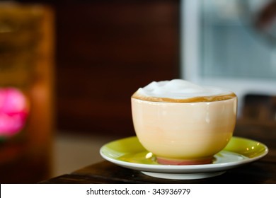 Cup Of Latte Art Coffee On Wood Table In Side View