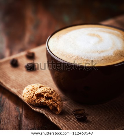 Cup of latte coffee with biscotti. Symbolic image. Rustic wooden background. Close up. 