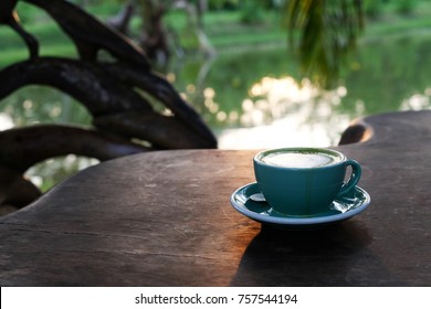 A Cup Of Matcha Green Tea Latte On Wooden Table. Tea Time At Sunset.