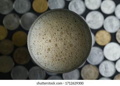 A Cup Of Milk Tea Shot From The Top Down Angle With Indian Currency In Coins Laid Out As Background