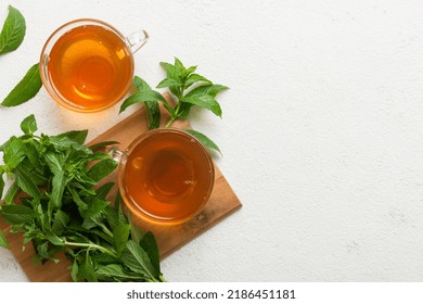 Cup of mint tea on table background. Green tea with fresh mint top view with copy space.