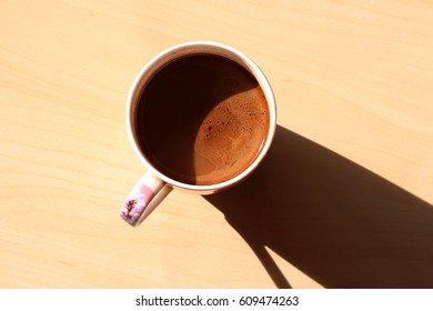 Cup of morning coffee with milk. Natural sunlight - Shutterstock ID 609474263