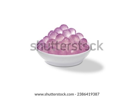 Cup of Pearls Bubble Tea closeup isolated on white background. Bowl of konjac 3Q boba pearls tapioca use for topping milk tea drinks. Taro flavor jelly tapioca for bubbles drinks                     