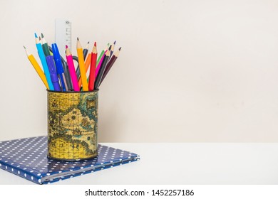 Cup with pencils on notebook