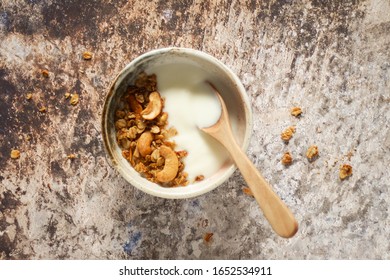 A Cup Of Plain Yogurt With Granola And Cashew Nuts In Warm Light.