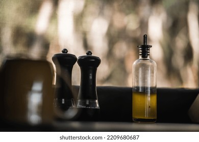 Cup And Seasoning Of Salt And Pepper Arranged Next To A Glass Bottle With Oil Next To The Mosquito Net Of The Kitchen Of The Tent Among The Trees In The Forest, Tarawera Lake, New Zealand