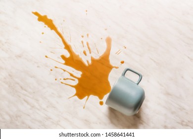 Cup with spilled drink on light background
