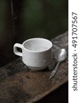 Cup and spoon in raining while on balcony. Motion blur of raining.