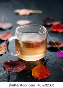 Cup Of Tea With Autumn Leaves On A Wet Stone Background