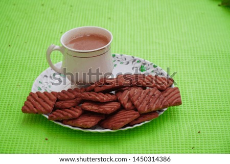 cup of tea and biscuits with green background. cookies and tea