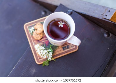 A Cup Of Tea And Biscuits On The Porch Of A Wooden House