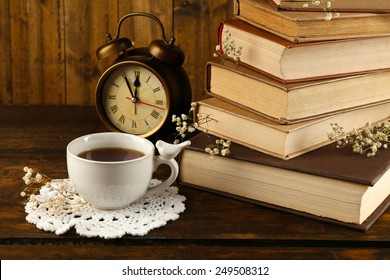 Cup Of Tea With Books And Clock On Wooden Background