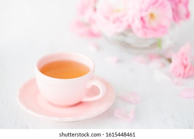 Cup of tea and bouquet  of  pink  roses on rustic table. - Powered by Shutterstock