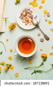 Cup Of Tea With Brown Candi Sugar And Flowers, Top View