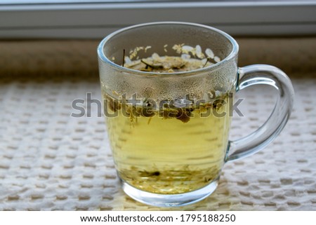A cup of tea with chamomile is one white textule, copyspace