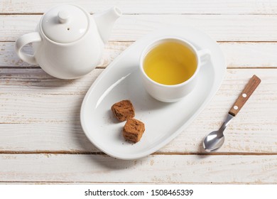 cup of tea with chocolate candy on wooden table