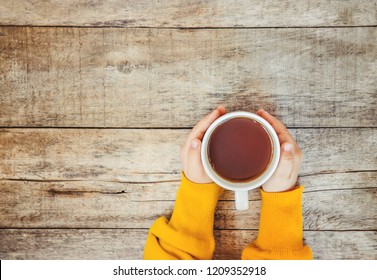 Cup Of Tea In The Hands Of A Child And A Cozy Autumn Background. Selective Focus. Kids.